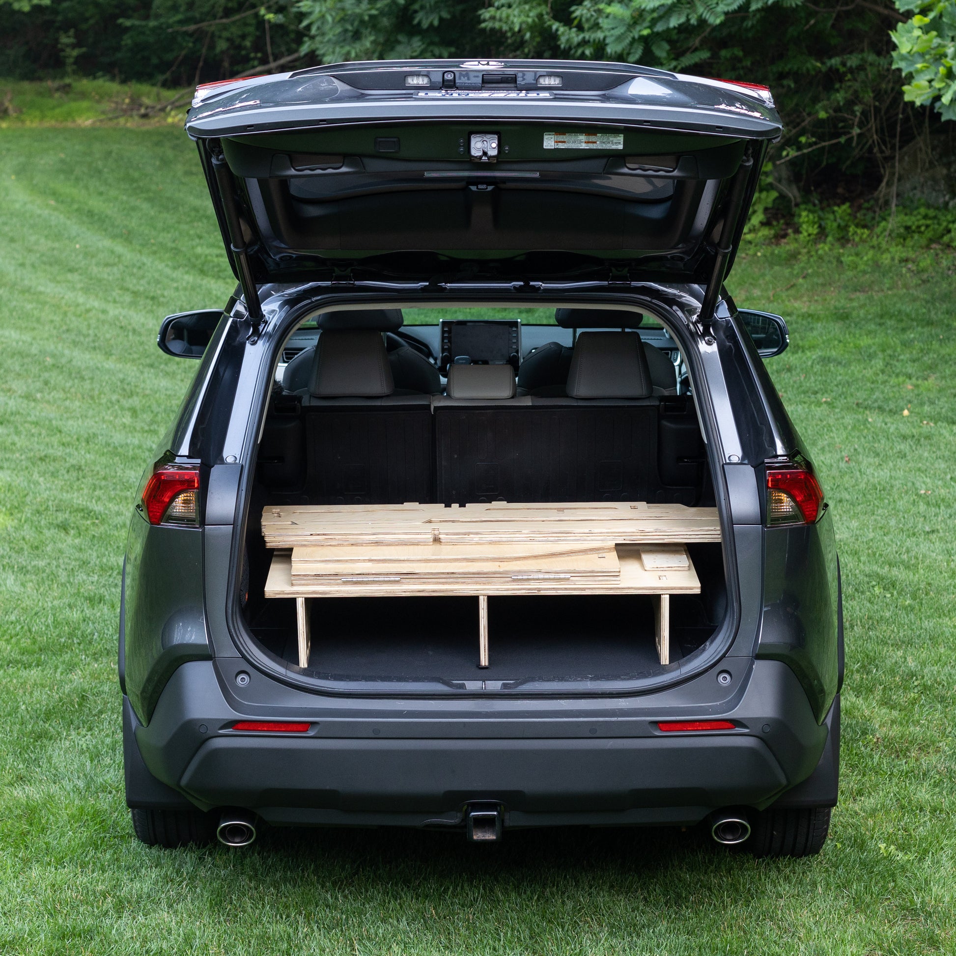 The trunk of a CarToCamp Toyota RAV4 Sleeping Platform with storage space.