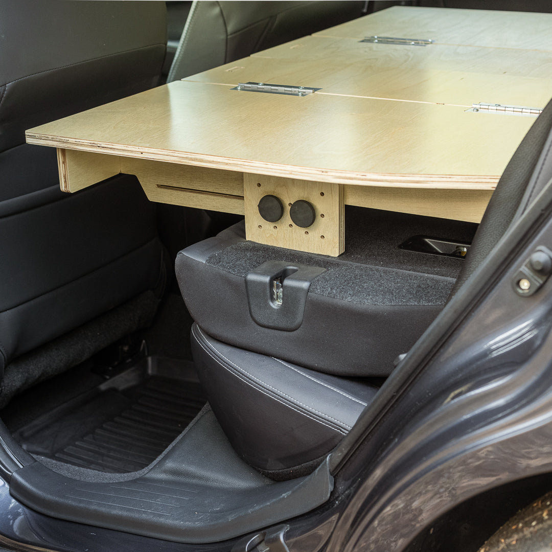 A CarToCamp Subaru Outback Sleeping Platform with a desk and storage space in the back seat.